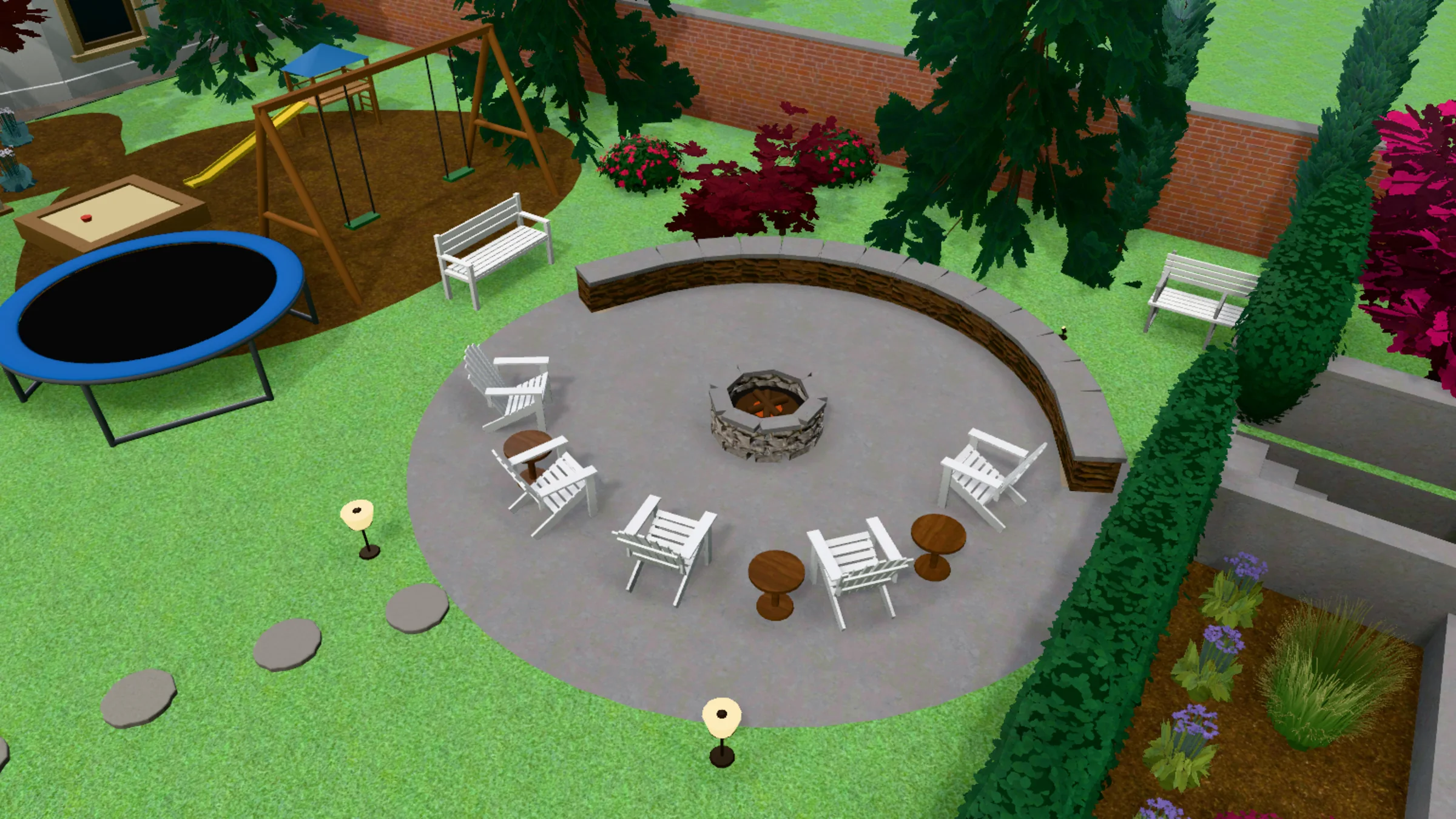 A 3D model of a round paved fire pit area from above. A stone fire pit sits in the centre with its embers glowing, a curved low stone seat wall runs round the back, and five white wooden Adirondack chairs and two small round tables are set in an arc. Stepping stones lead away across the lawn. Behind are a swing set, a sandpit and a trampoline on a wood-chip play area, and a brick boundary wall.