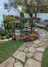 Design a cozy, inviting yard with a small circular water fountain at its center, gently bubbling ...